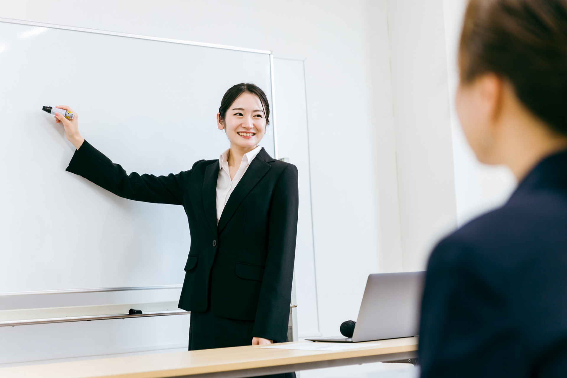 説明会・勉強会で発表をする大学生（教師）
