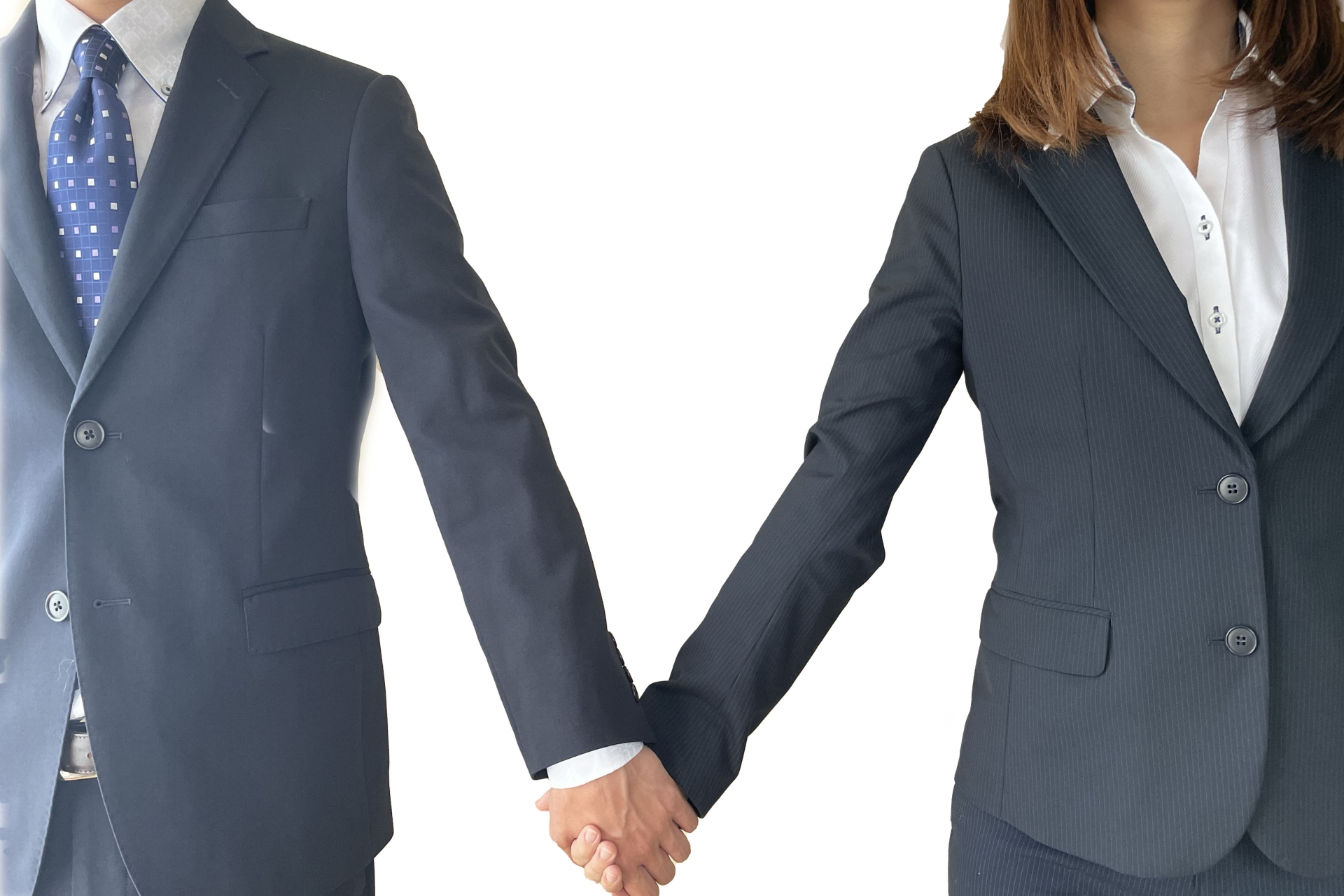 手をつなぐスーツの男性と女性